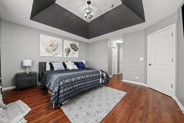 a bedroom with a bed and a chandelier