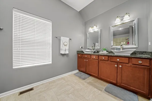 a bathroom with a granite countertop sink vanity and mirror