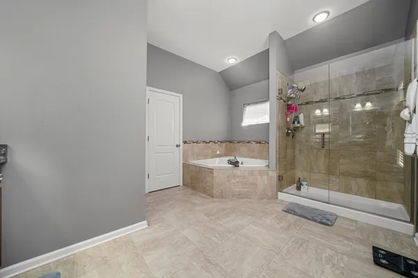 a bathroom with a tub shower sink and mirror
