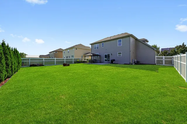 a view of a house with a yard and sitting area