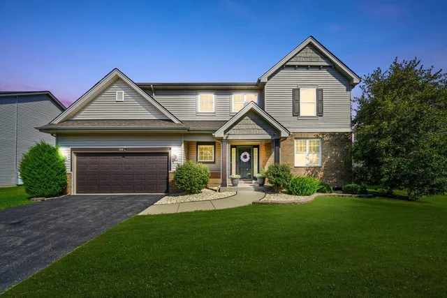 a front view of a house with a yard and garage