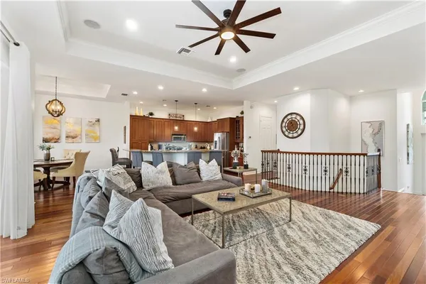 a kitchen with stainless steel appliances a dining table chairs and wooden floor