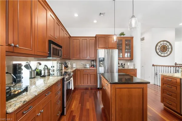 a large kitchen with lots of counter space dining table and stainless steel appliances