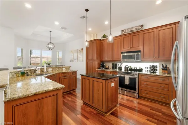 a kitchen with stainless steel appliances granite countertop a sink a stove and a refrigerator