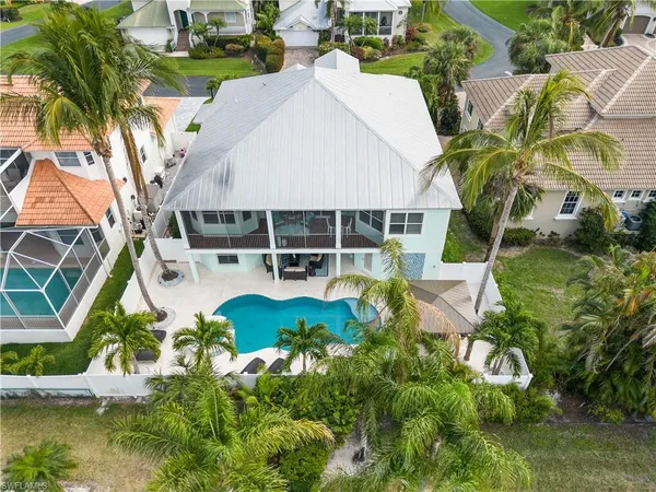 an aerial view of a house with swimming pool and garden