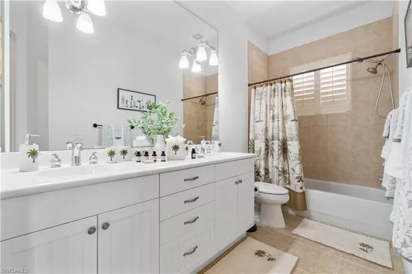 a bathroom with a double vanity sink toilet mirror and bathtub