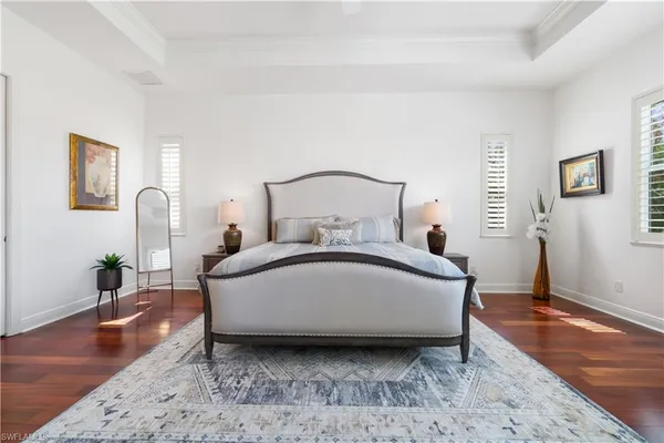 a bedroom with a bed chair and wooden floor