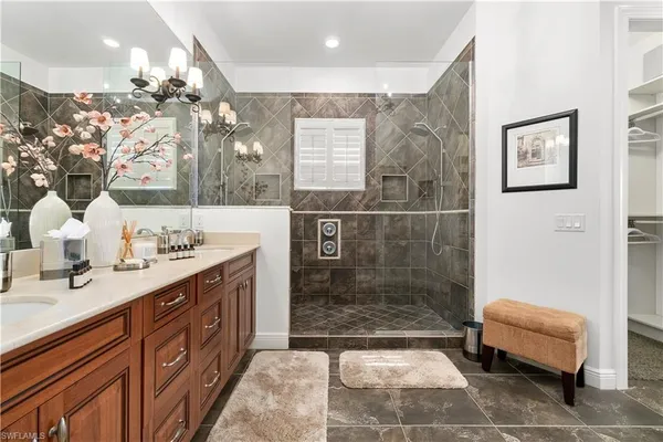 a spacious bathroom with a double vanity sink a mirror and a shower