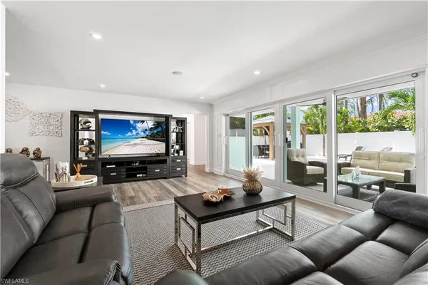 a room with furniture pool table wooden floor and windows