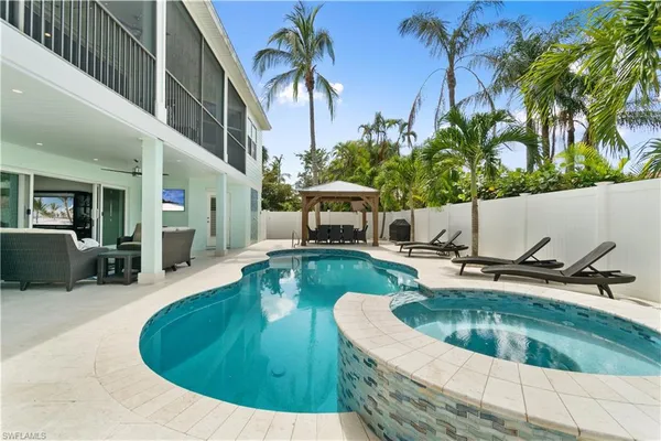 a view of a house with a swimming pool and sitting area