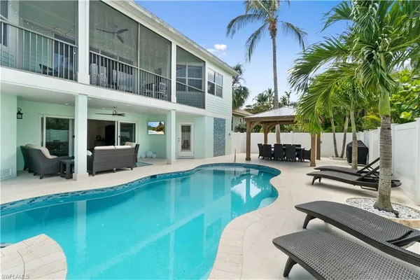a view of a house with swimming pool and sitting area