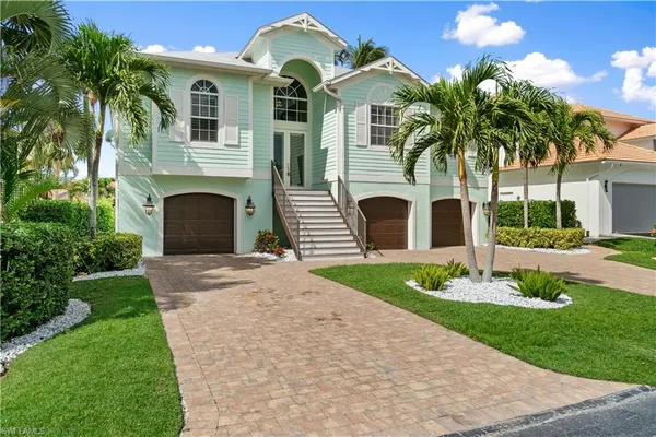 a front view of a house with a garden and yard