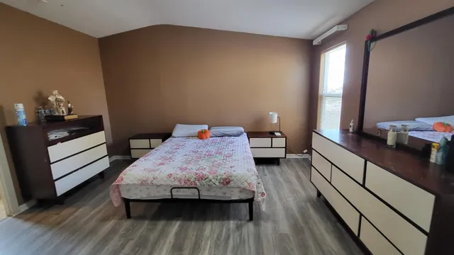 a bedroom with a bed and wooden floor