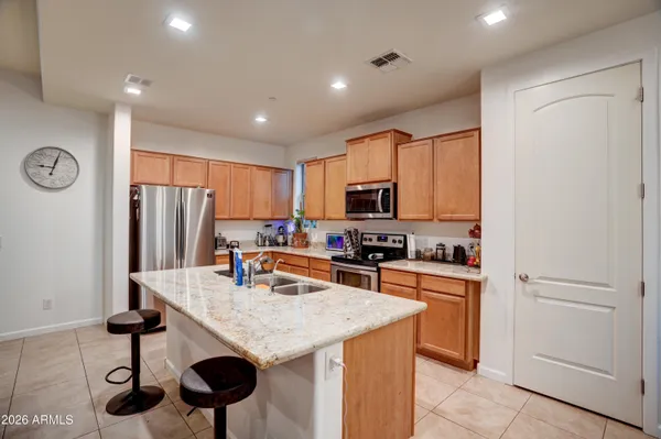 a kitchen with stainless steel appliances granite countertop a refrigerator a stove a sink dishwasher and microwave with wooden floor