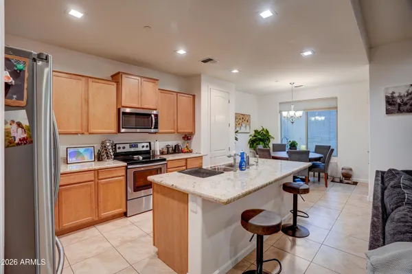 a kitchen with stainless steel appliances granite countertop a stove top oven a sink dishwasher and a refrigerator