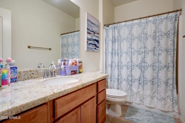 a bathroom with a granite countertop sink mirror vanity and toilet