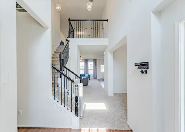 a view of a hallway with wooden floor and staircase