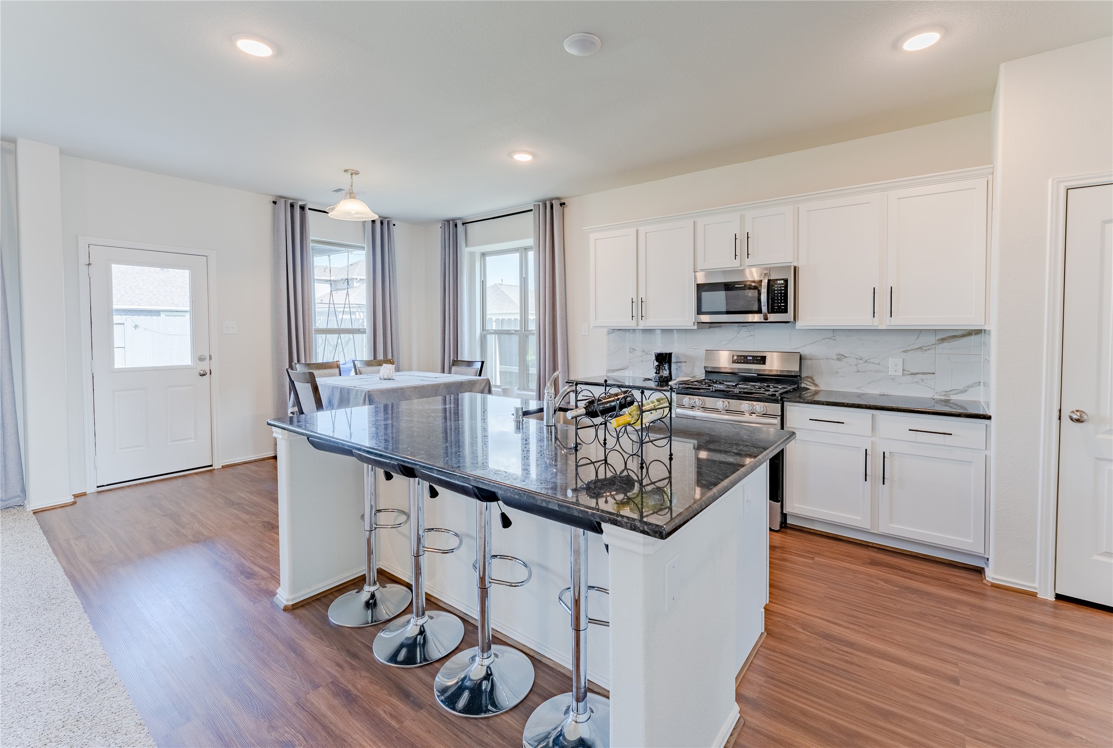 8327 Threadfin Way Fulshear, TX 77441 - Photo 8 of 40 a kitchen with stainless steel appliances granite countertop a sink a stove a microwave a refrigerator and cabinets