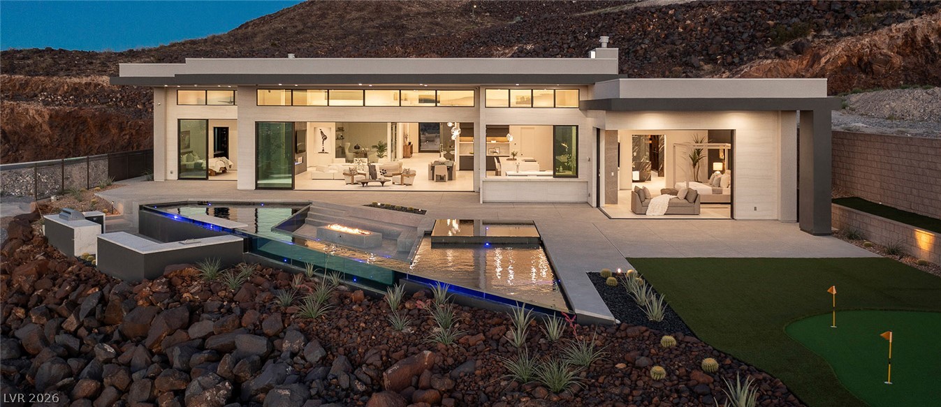 563 Grand Rim Drive Henderson, NV 89012 - Photo 55 of 70 Modern desert oasis featuring a striking infinity pool with fire feature, outdoor kitchen, and private putting green.