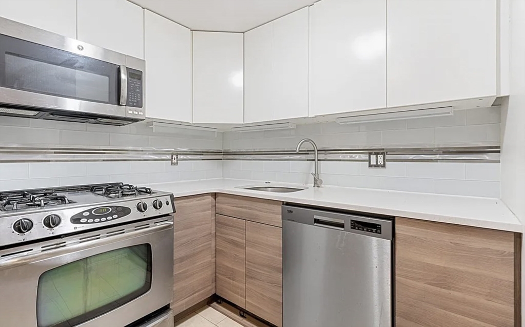170 Tremont Street, Unit 905 Boston, MA 02111 - Photo 4 of 14 a kitchen with cabinets stainless steel appliances and sink