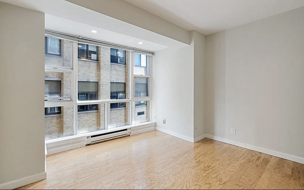 170 Tremont Street, Unit 905 Boston, MA 02111 - Photo 7 of 14 a view of an empty room with a window and cabinet