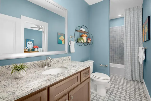 a bathroom with a granite countertop sink toilet mirror vanity and shower