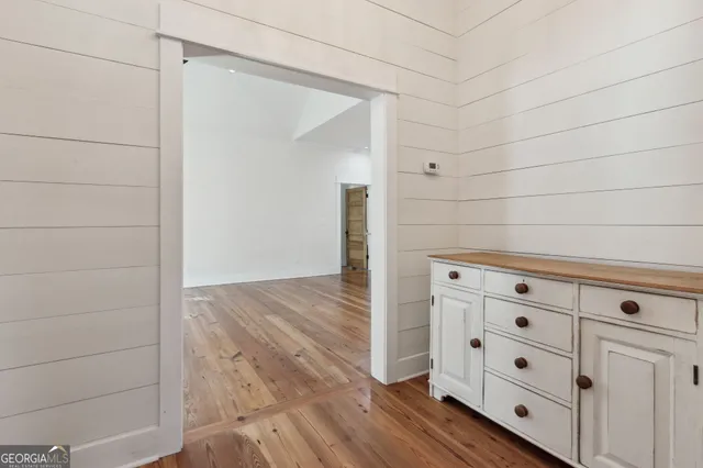 a large white kitchen with kitchen island a sink dishwasher a stove and a refrigerator with wooden floor