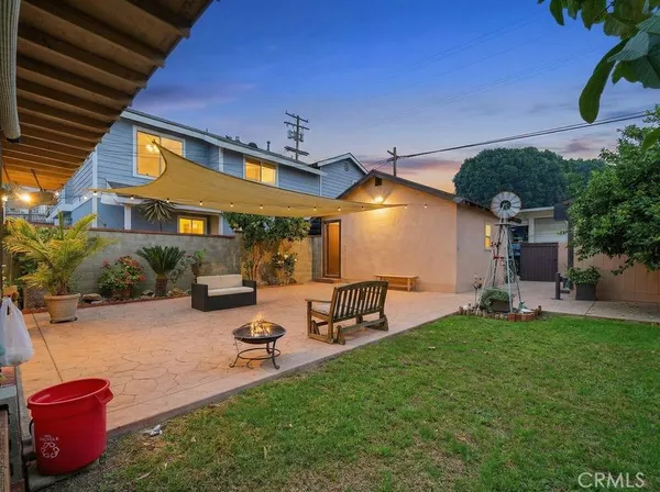 a view of a backyard with table and chairs under an umbrella