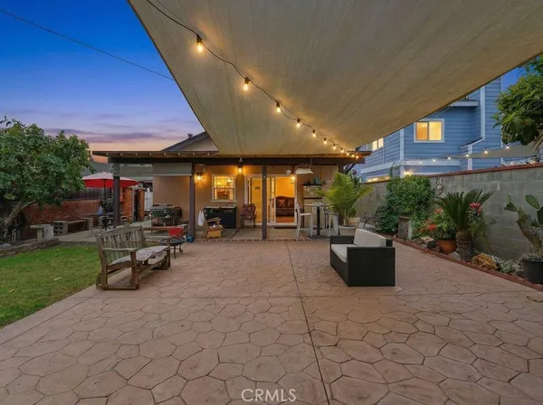 a view of a patio with table and chairs potted plants and a ceiling fan