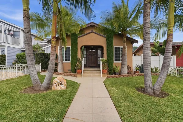 a front view of a house with a garden and plants