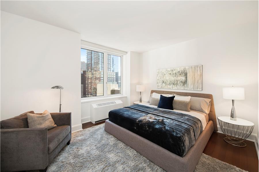 60 Riverside Boulevard, Unit 810 Manhattan, NY 10069 - Photo 4 of 11 a bedroom with a large bed and a couch