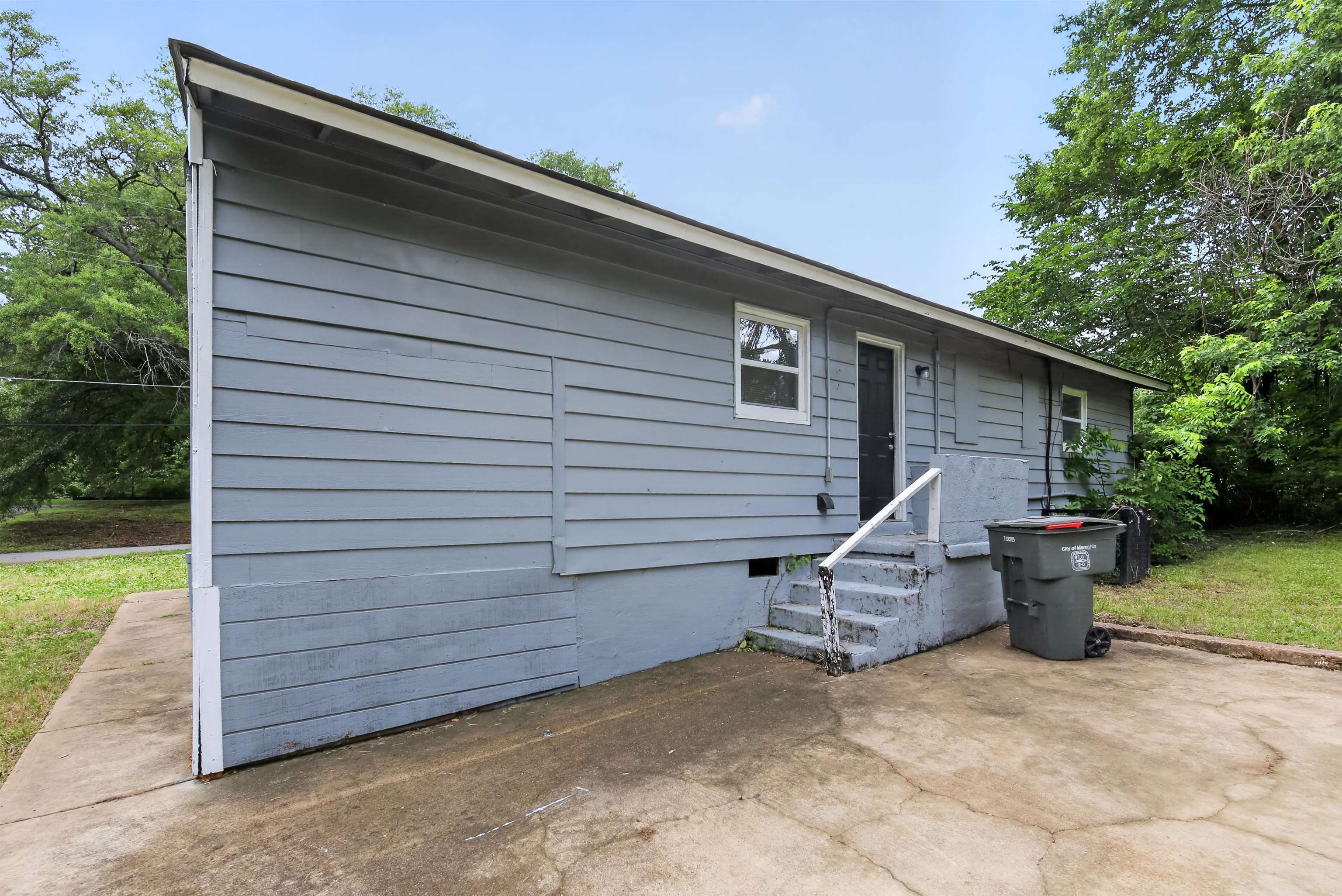 4838 Manson Road Memphis, TN 38109 - Photo 3 of 28 Exterior featuring horizontal siding, white trim, a rear entry door, and concrete steps with a handrail