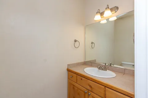a bathroom with a granite countertop sink a toilet and a mirror