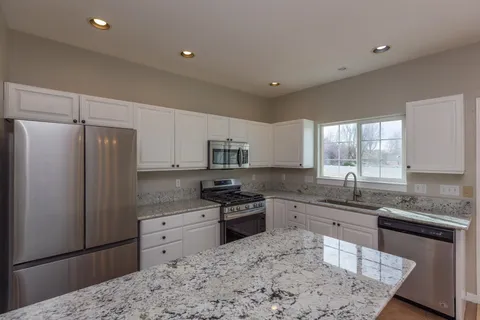 a kitchen with a sink granite counter tops and a window