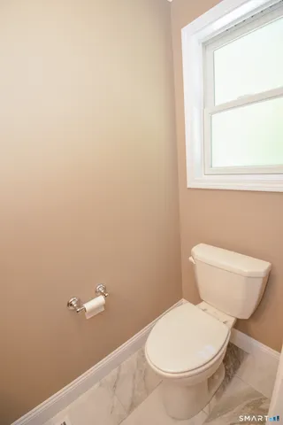 a white toilet sitting next to a window