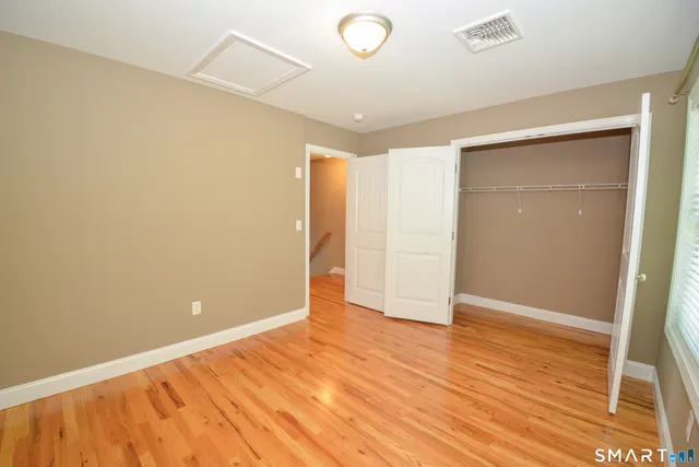 an empty room with wooden floor and closet