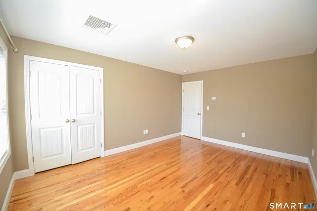 a view of an empty room with wooden floor