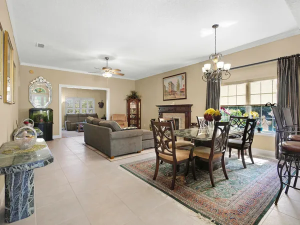 a living room with furniture a chandelier and a dining table