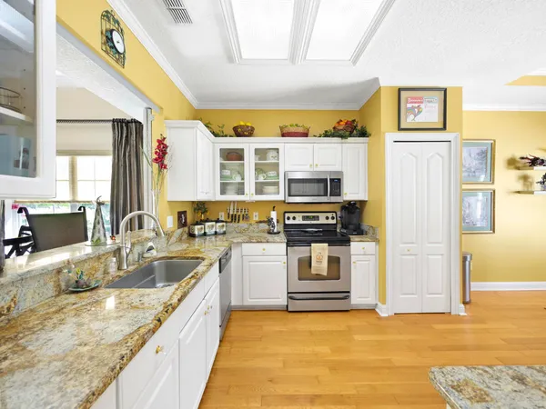 a large kitchen with stainless steel appliances granite countertop a sink and cabinets