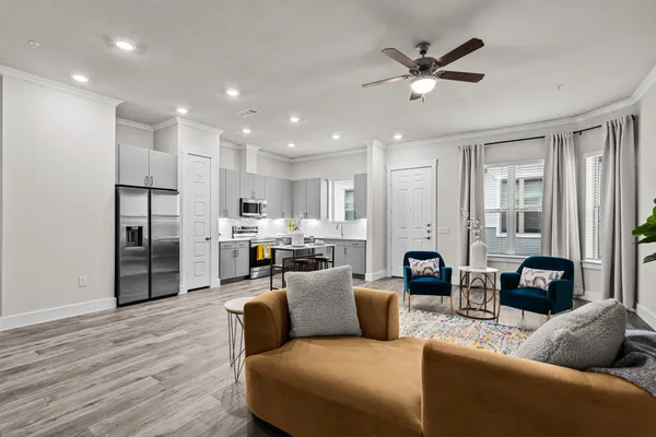 a living room with furniture kitchen view and a refrigerator
