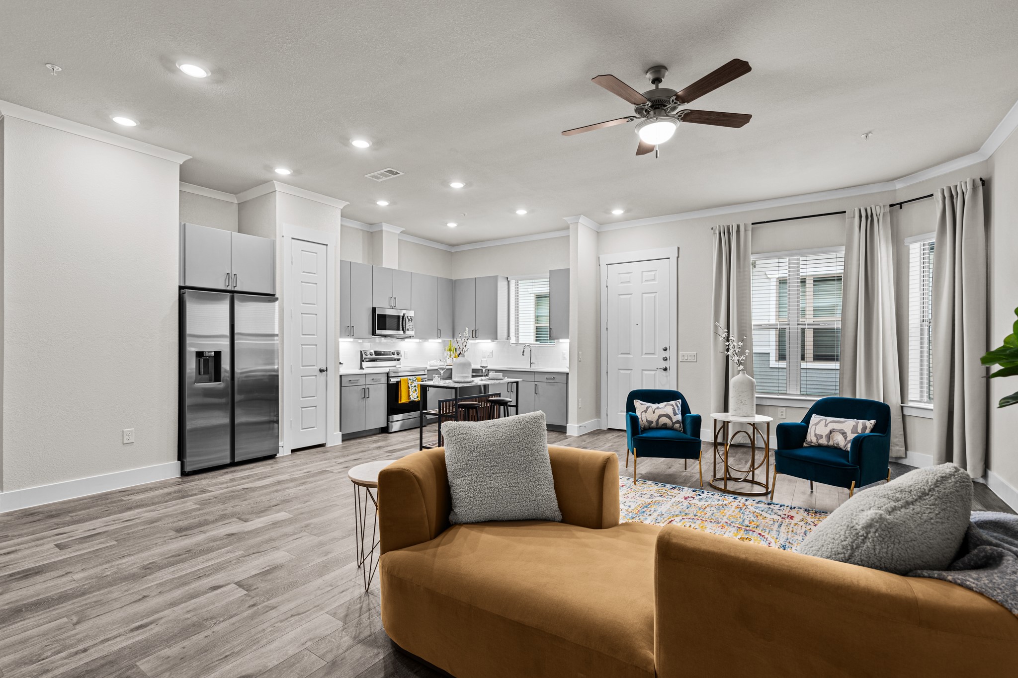 a living room with furniture kitchen view and a refrigerator