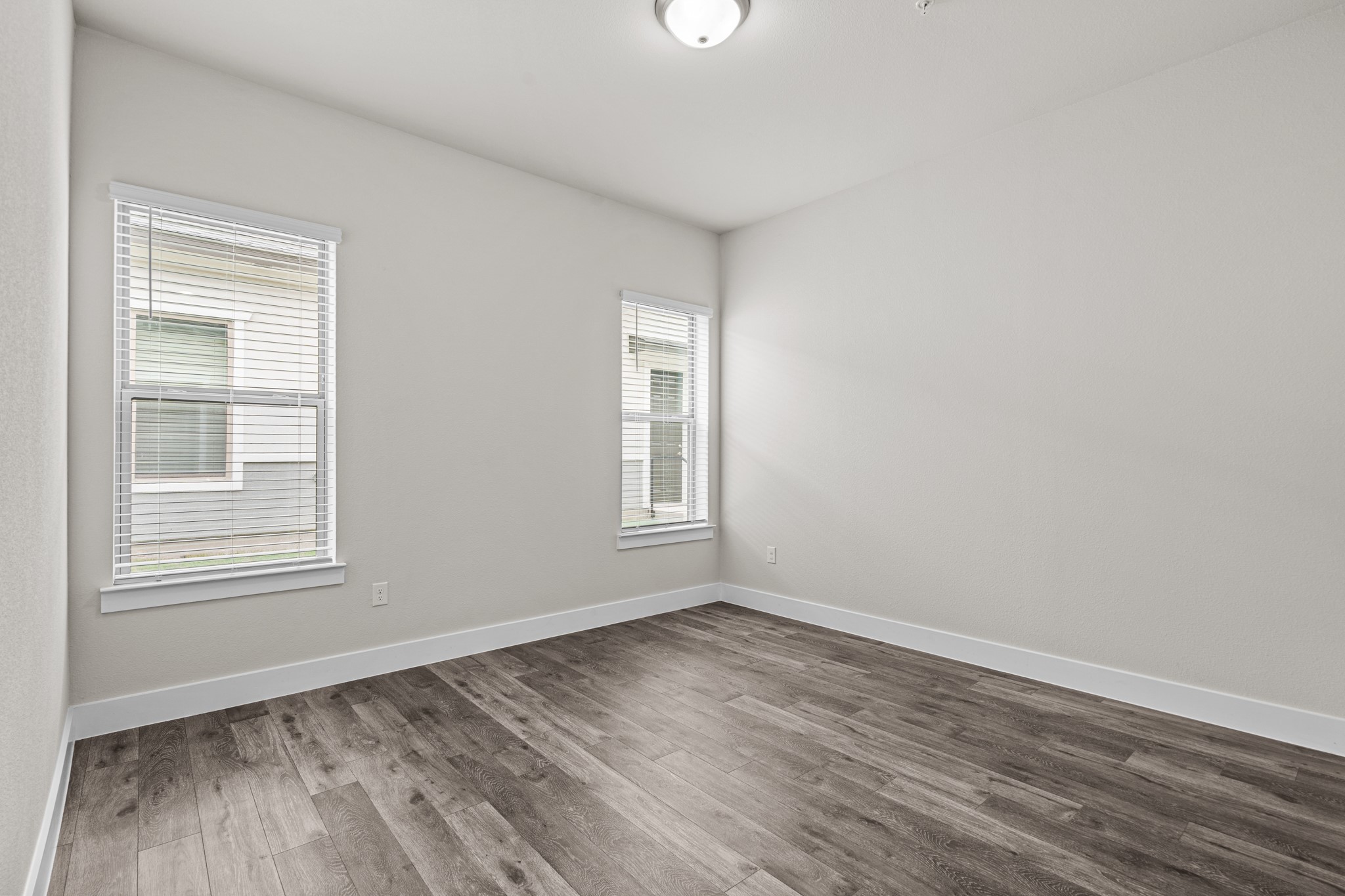 865 Limmer Loop, Unit 1014 Hutto, TX 78634 - Photo 12 of 37 a view of an empty room with wooden floor and a window