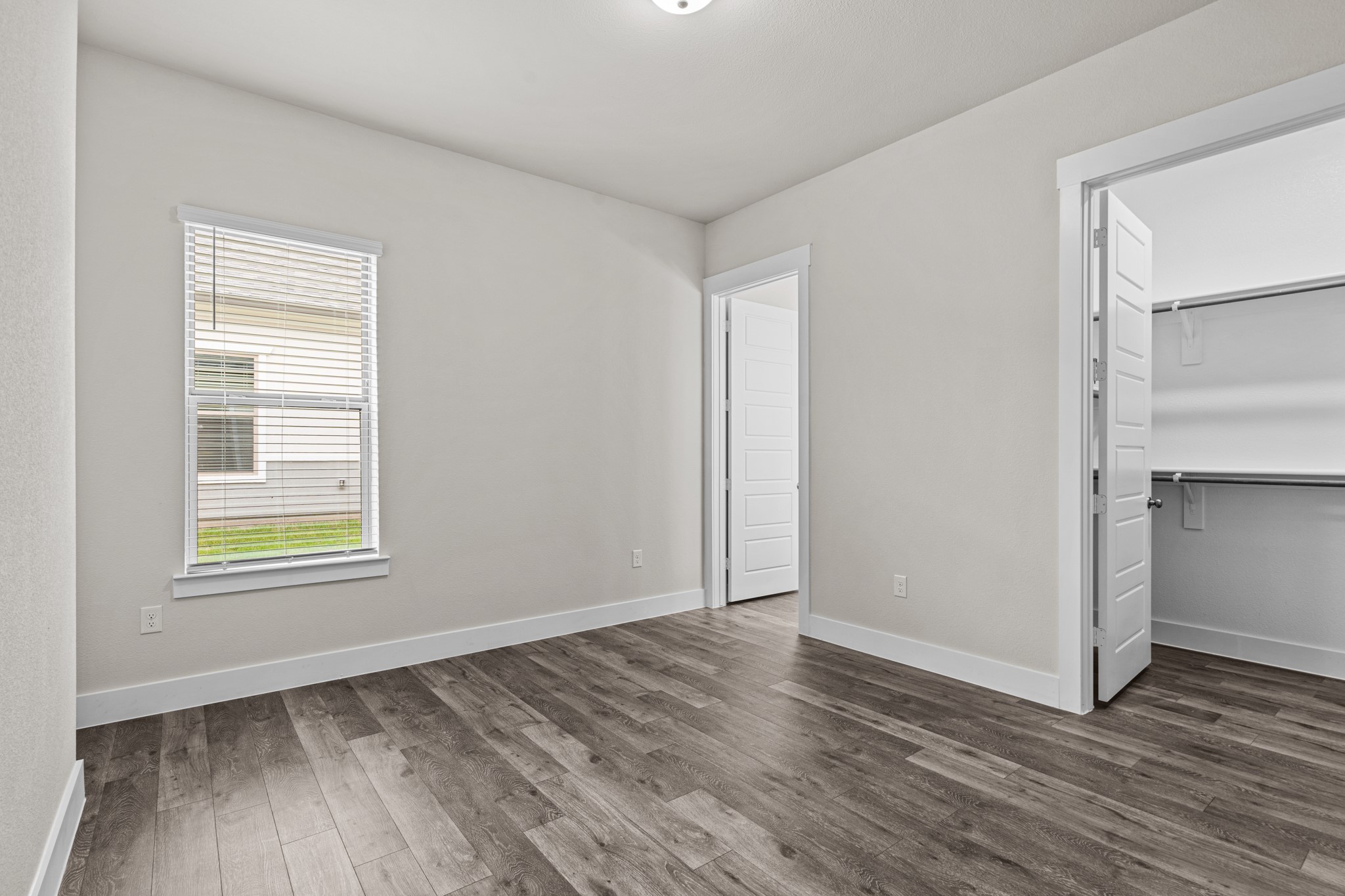 865 Limmer Loop, Unit 1014 Hutto, TX 78634 - Photo 18 of 37 a view of an empty room with wooden floor and a window