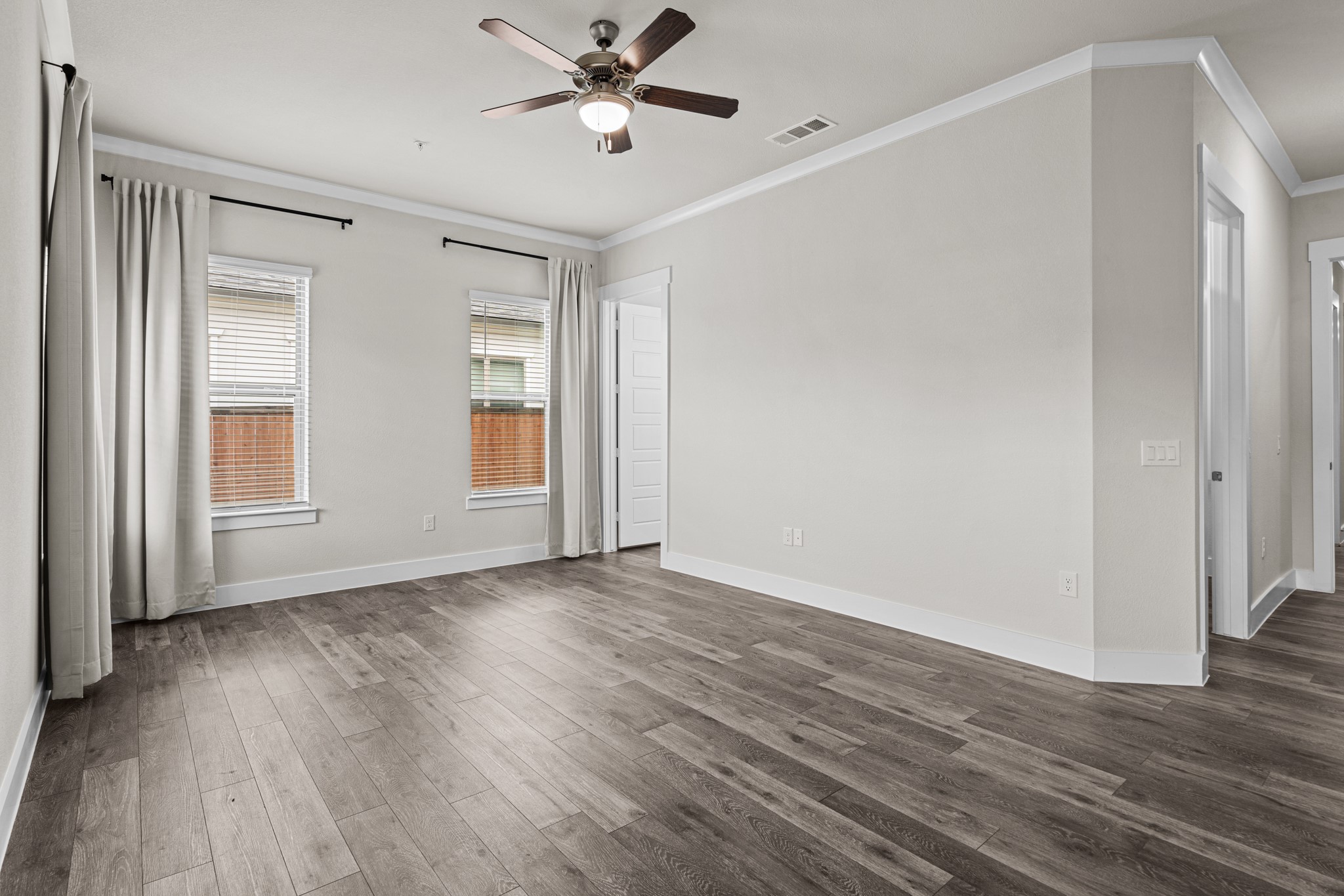865 Limmer Loop, Unit 1014 Hutto, TX 78634 - Photo 29 of 37 a view of an empty room with wooden floor and a window