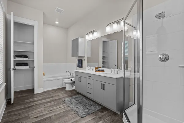 a bathroom with a double vanity sink toilet mirror and bathtub