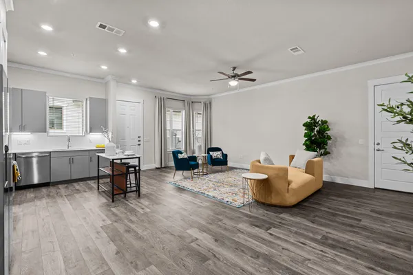 a living room with furniture and a wooden floor