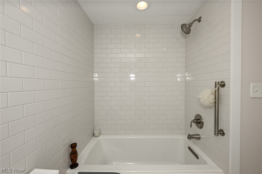 275 North Portage Path, Unit 3B Akron, OH 44303 - Photo 13 of 16 Bathroom with a white subway tile surround, a built-in bathtub, and a brushed nickel shower head and fixtures