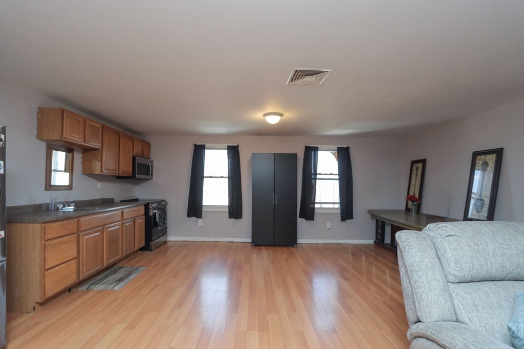 205 Elm Street Westfield, MA 01085 - Photo 7 of 24 a large kitchen with stainless steel appliances granite countertop a stove and a wooden floors