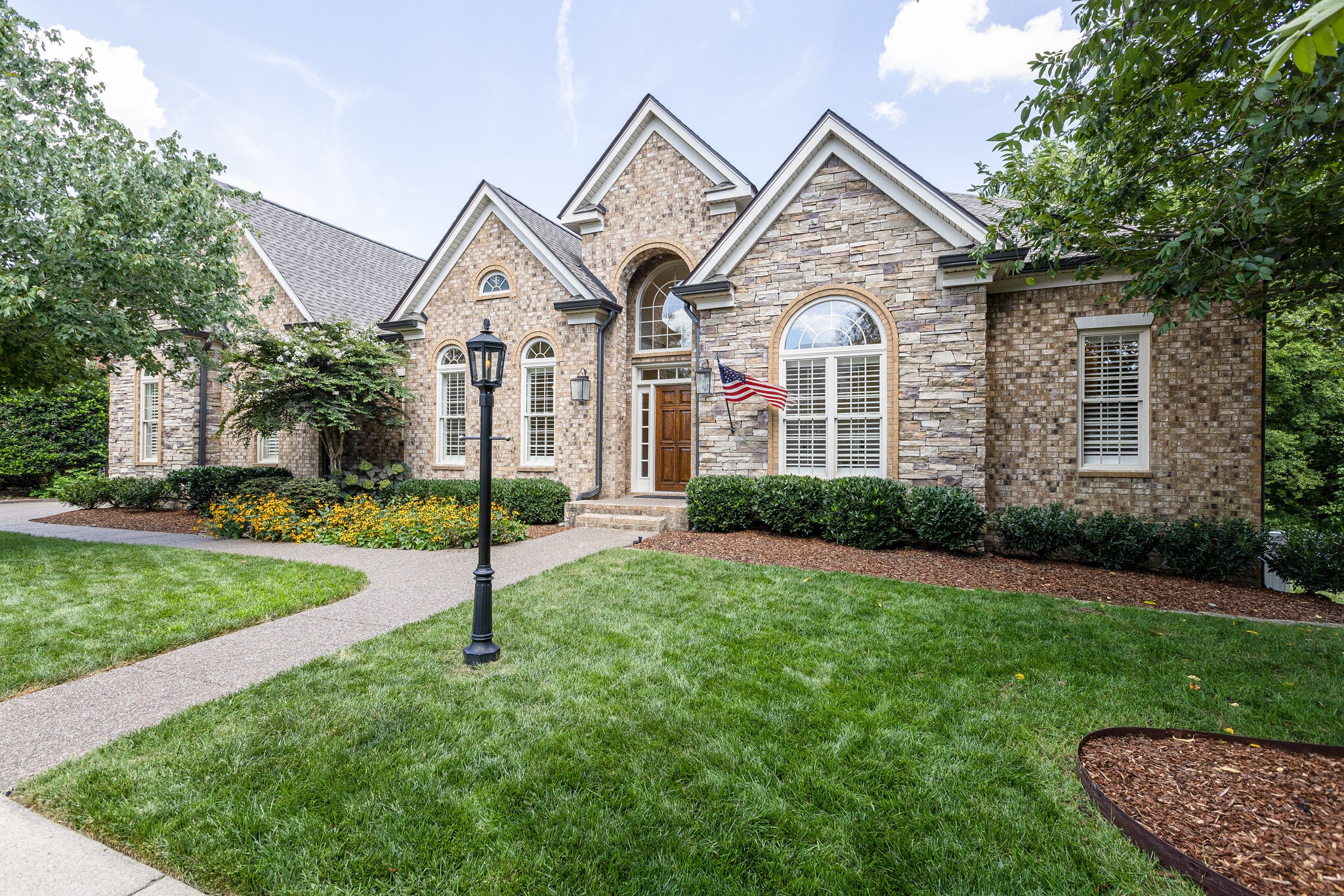 a front view of a house with a garden and plants