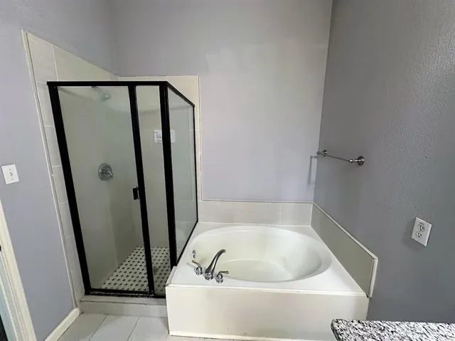 a bathroom with a tub and shower